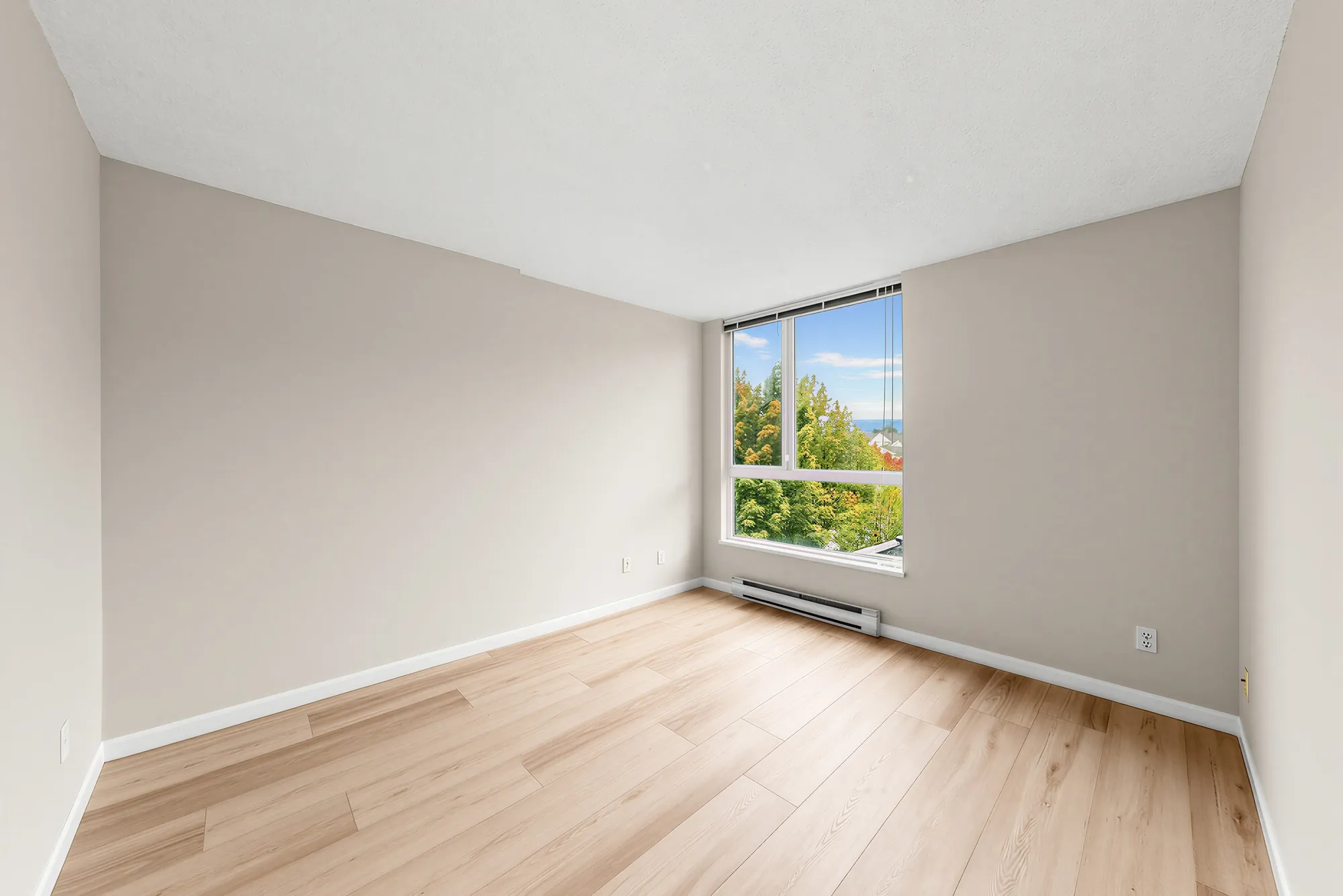 A bedroom from the doorway, window on the far wall