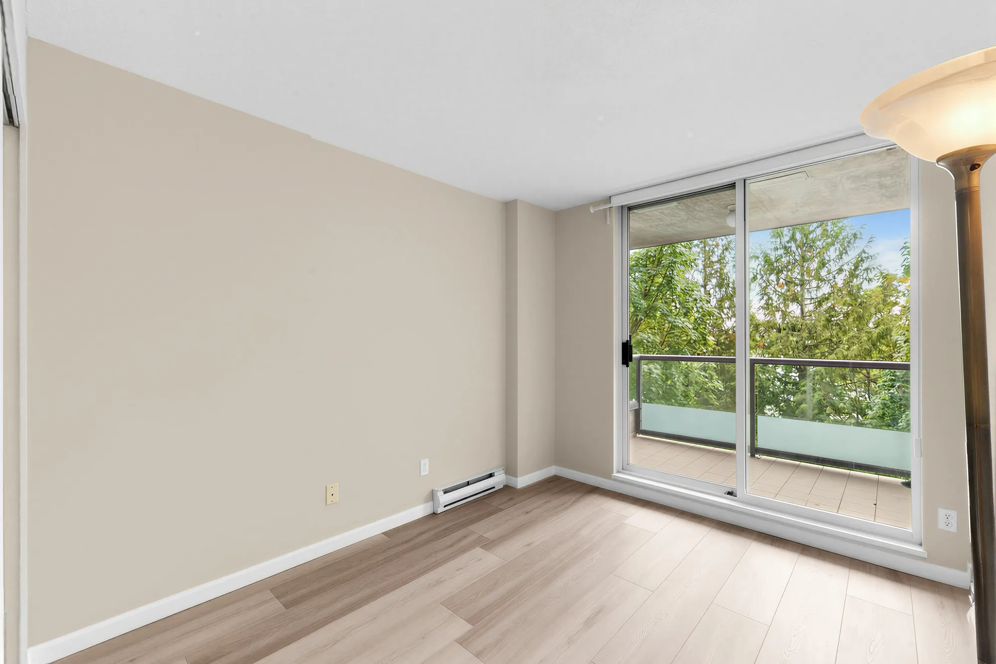 A bedroom with a sliding door to the balcony