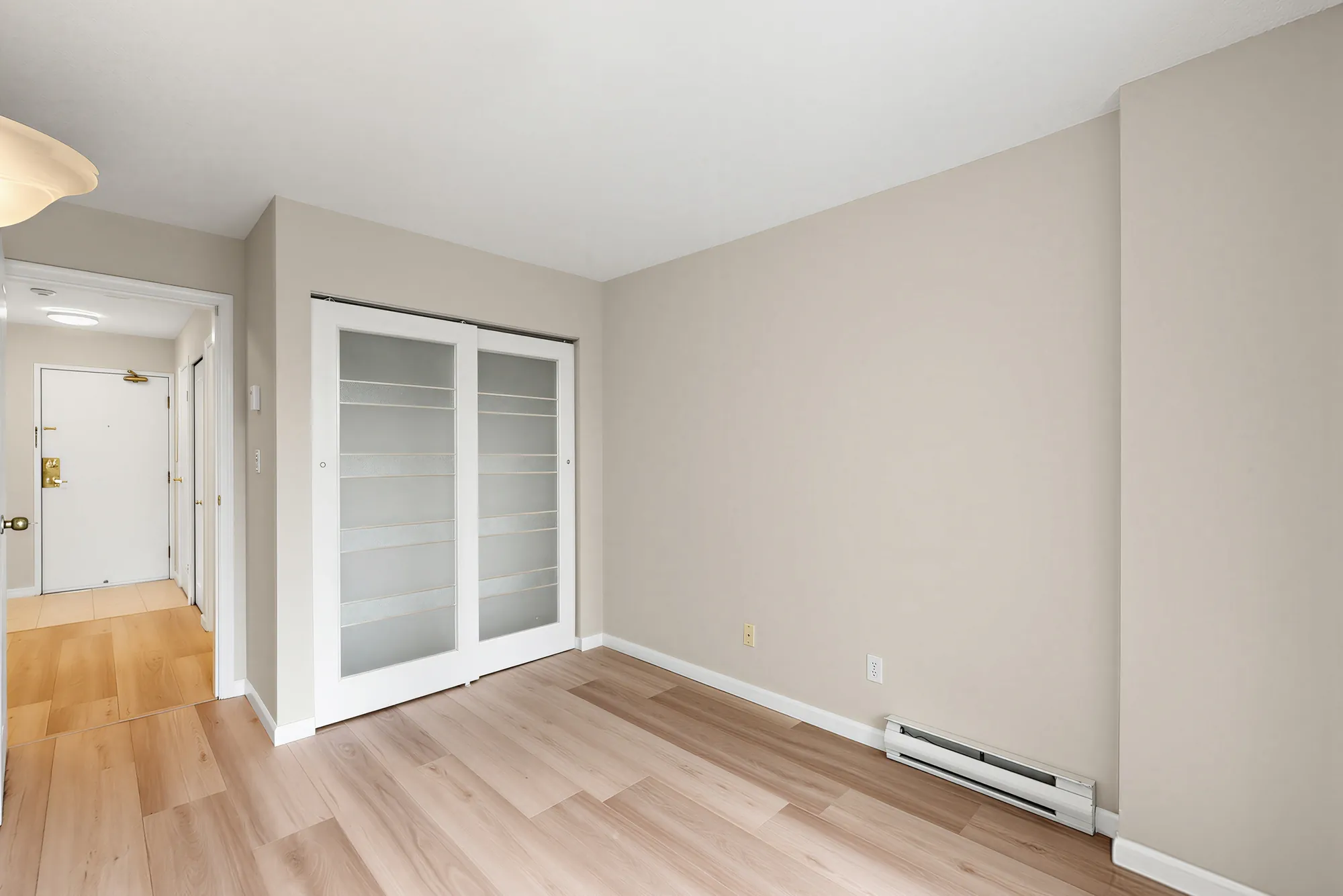A bedroom with mirrored closet doors along one wall