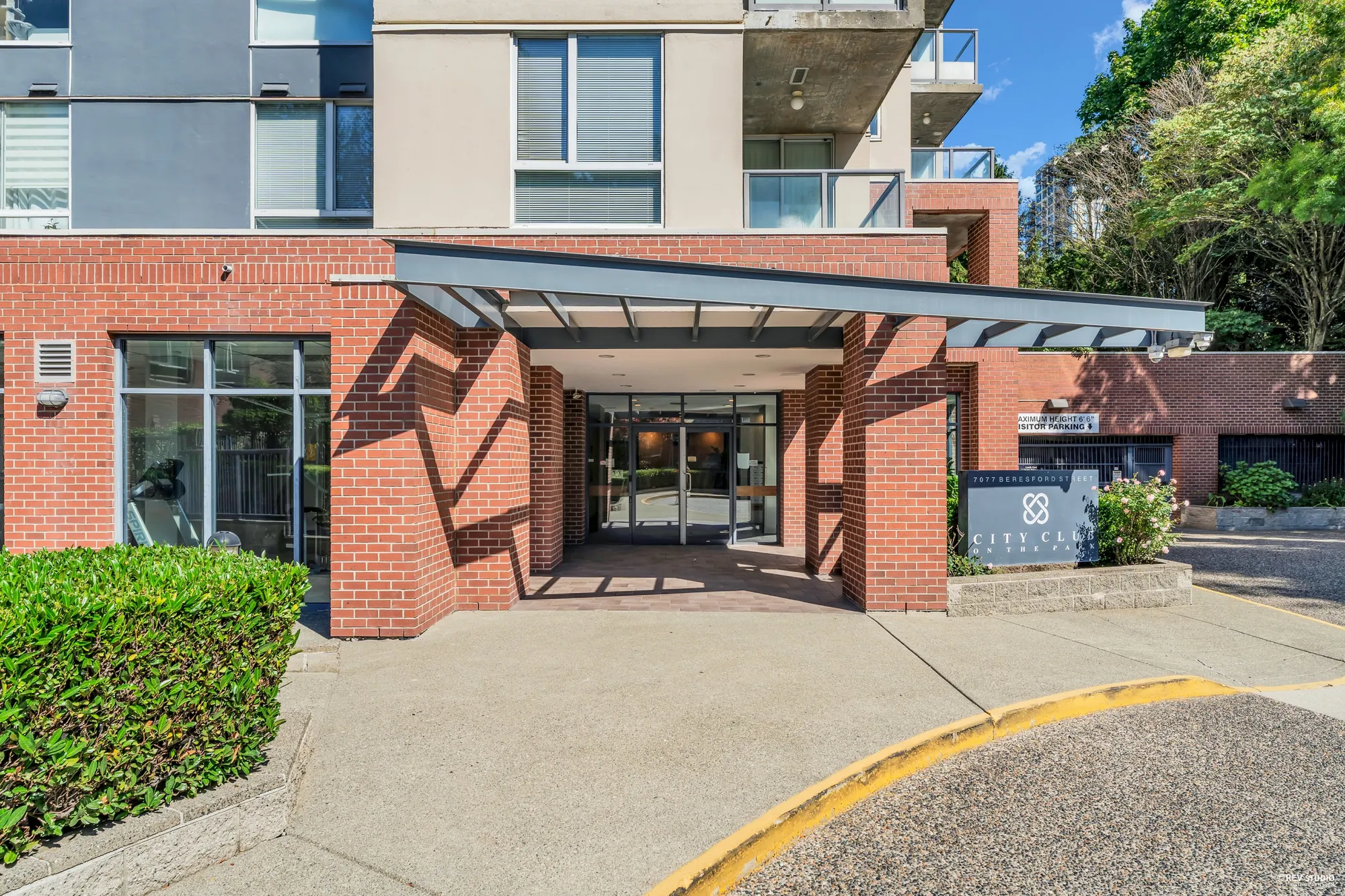 The covered entrance to the building, glass doors under a canopy