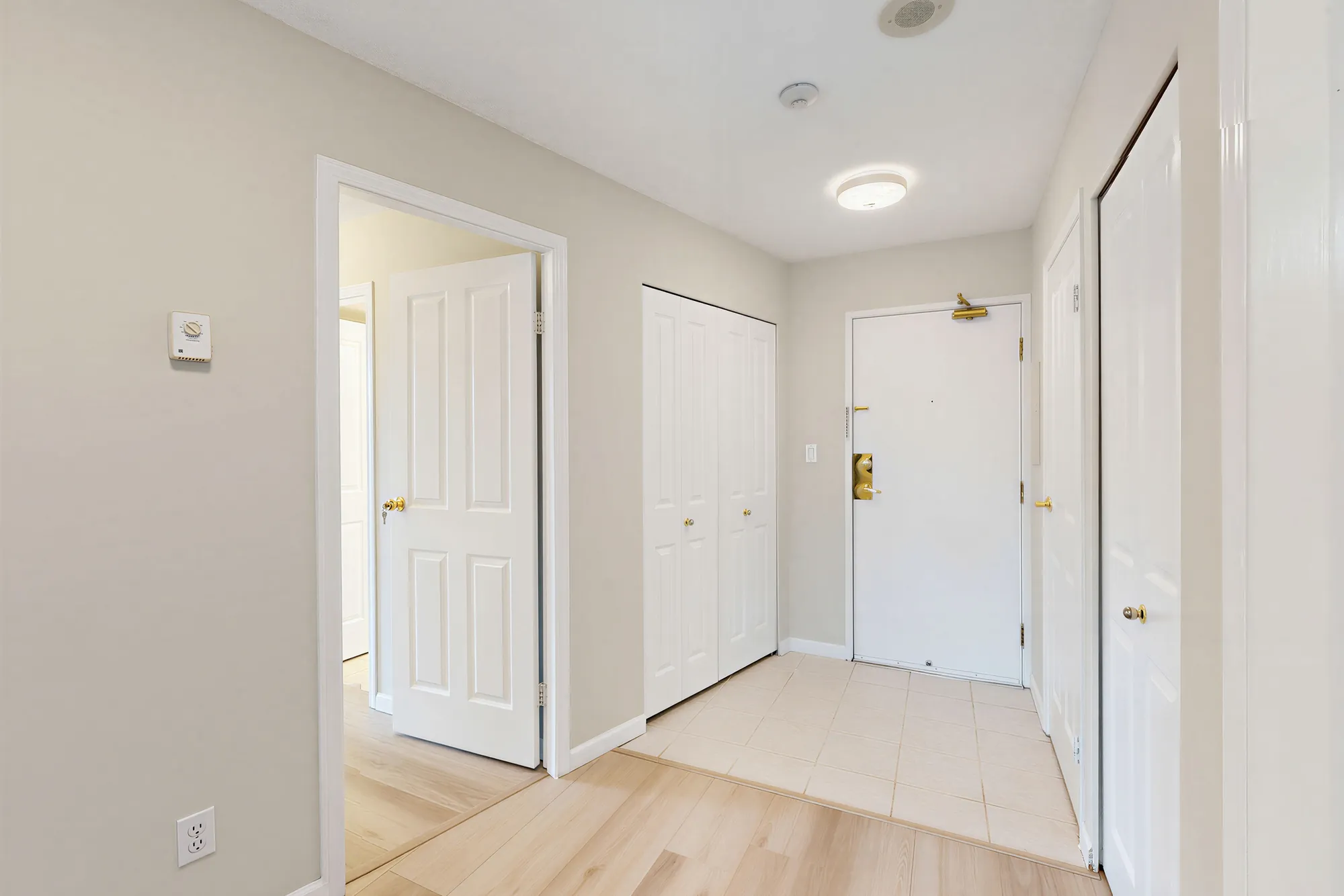 The entry with the front door and a coat cupboard beside it